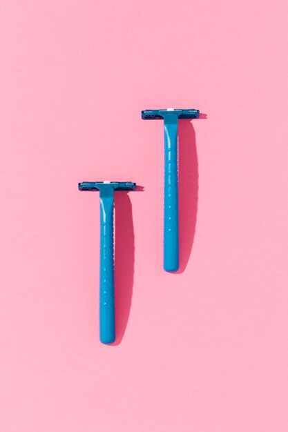 Lâminas de barbear de plástico azul em fundo minimalista