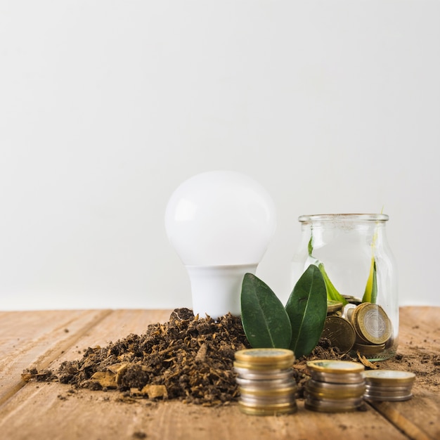 Foto grátis lâmpada com pilhas de jarra e moedas de vidro