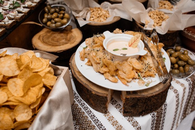 Lanches como batatas fritas, azeitonas e nozes estão na mesa da restauração