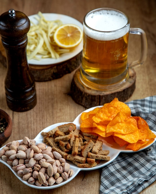 Lanches de cerveja, uma caneca de cerveja e um prato com limão e queijo