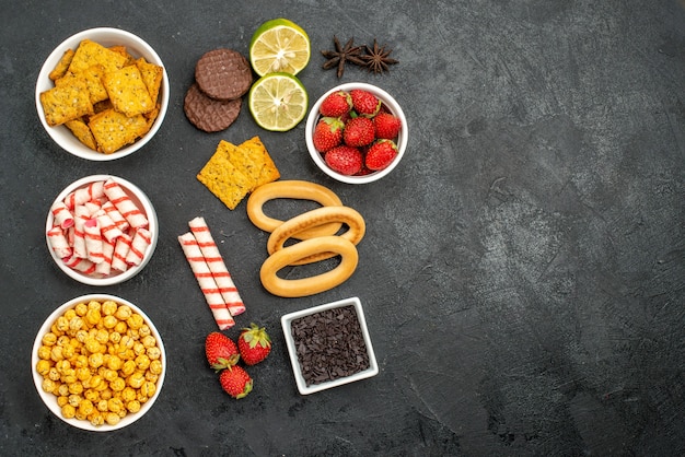 Foto grátis lanches saborosos com lima crakers e morangos suculentos cacoa flor, doce de natal em um fundo escuro com espaço livre