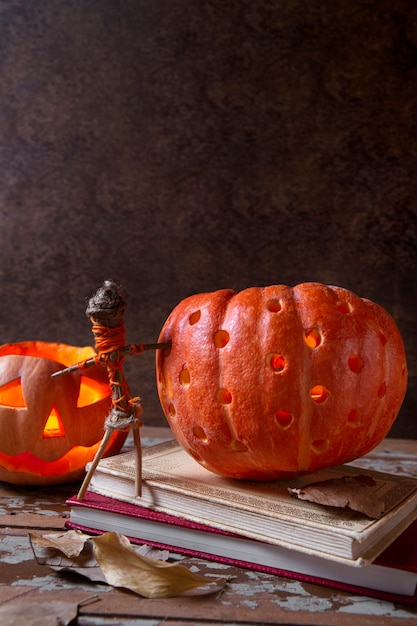 Foto grátis lanterna de abóbora esculpida de halloween assustador com estatueta feita de paus