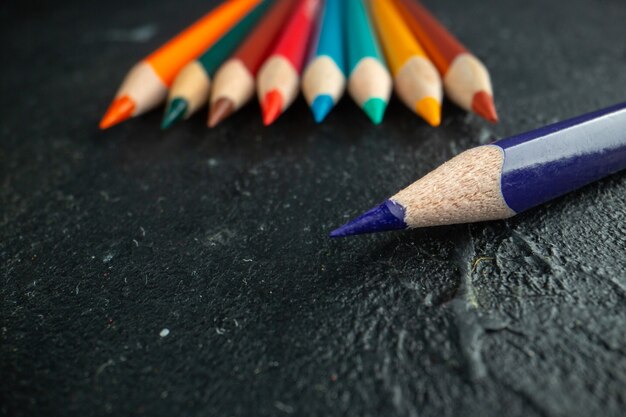 Foto grátis lápis coloridos de frente, delineados na cor escura da caneta de desenho, foto arte escolar