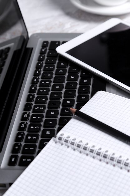 Laptop, bloco de notas e caneta em cima da mesa