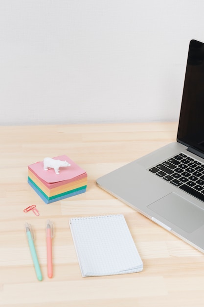 Laptop com bloco de notas na mesa de madeira