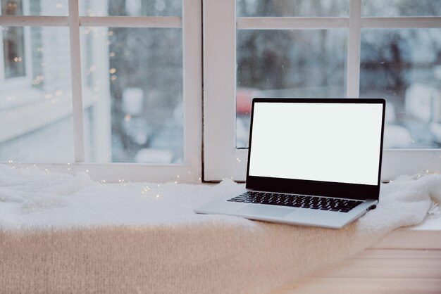 Laptop com lugar para texto no peitoril da janela computador autônomo com espaço de cópia na manta branca quente