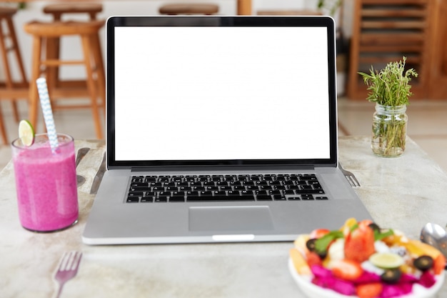 Foto grátis laptop com tela em branco na mesa