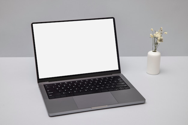 Laptop de alto ângulo e arranjo de flores
