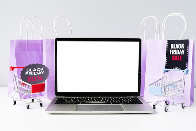 Laptop de vista frontal com maquete de carrinhos de compras