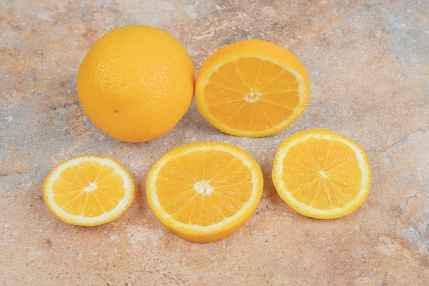 Laranja inteira fresca e fatias sobre fundo de mármore. foto de alta qualidade