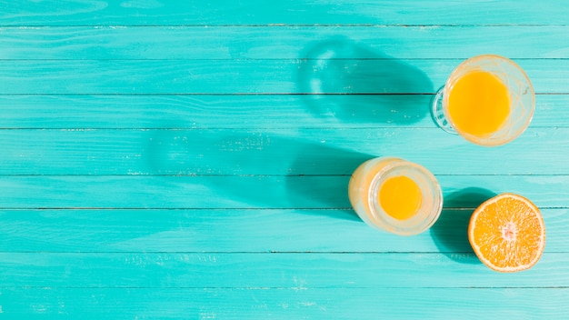 Laranja, jarra de suco e copo na mesa