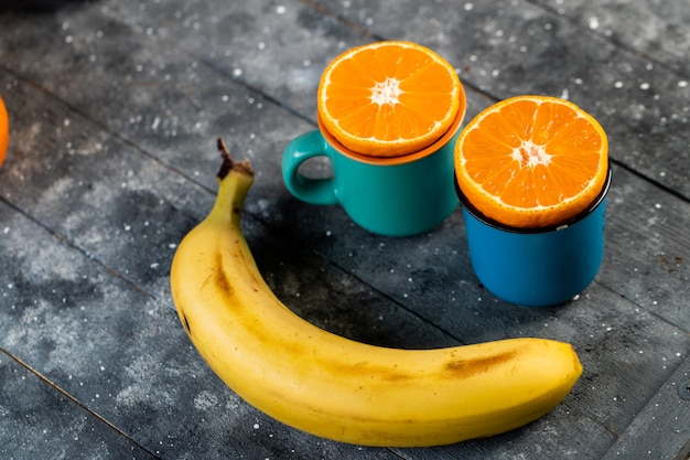 Laranjas picadas e banana em uma mesa de madeira