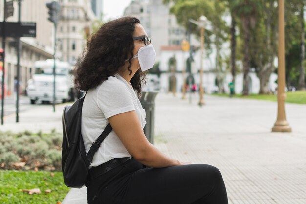 Lateralmente jovem vestindo uma máscara médica