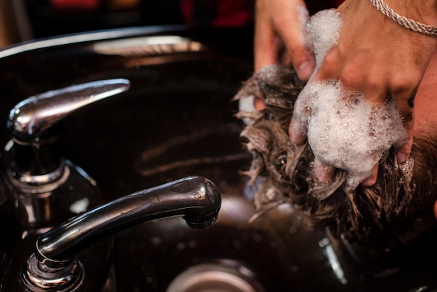 Lavar o cabelo com shampoo na barbearia