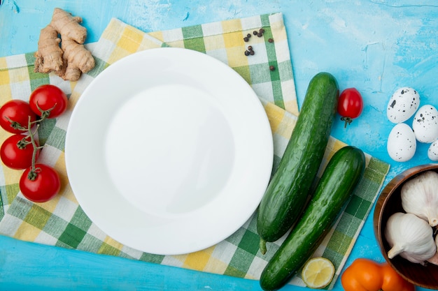 Legumes com prato vazio no pano na mesa azul