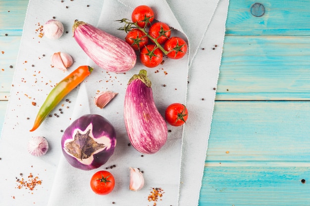 Foto grátis legumes e especiarias na toalha de mesa sobre a mesa de madeira