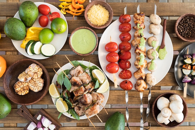 Foto grátis legumes e espetos de carne na mesa