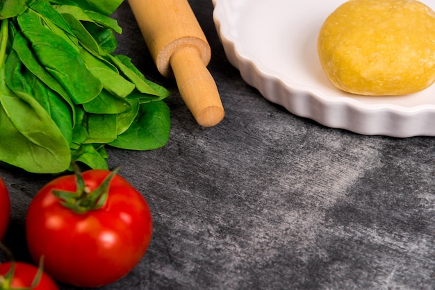 Foto grátis legumes e massa sobre a superfície de madeira cinza