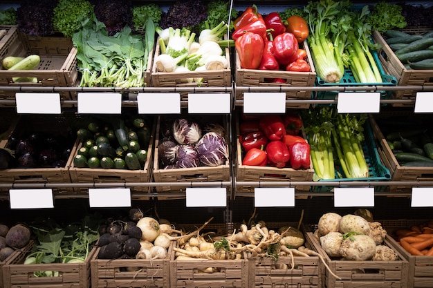 Legumes frescos com etiquetas de preço na prateleira de supermercado de mercearia