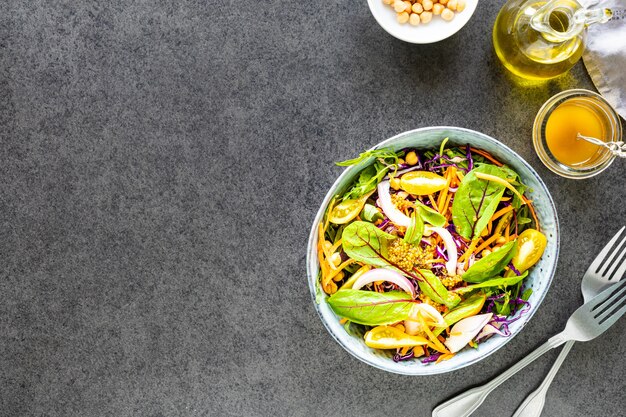 Legumes frescos e salada de frutas em um prato na pedra preta. Vista do topo