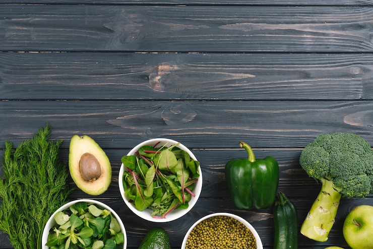 Foto grátis legumes frescos verdes na mesa de madeira preta