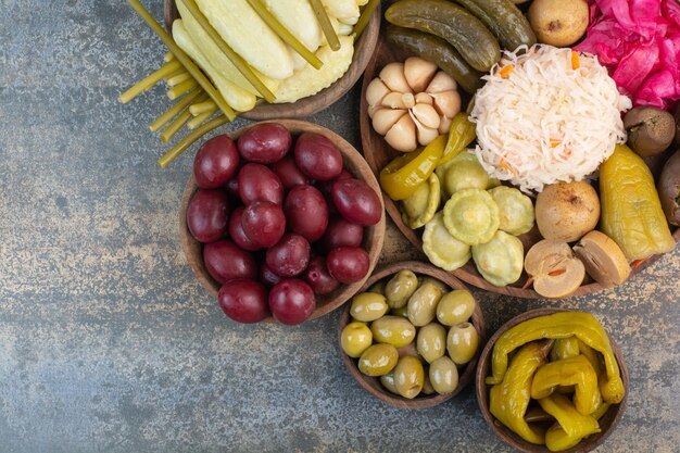 Foto grátis legumes salgados em tigelas de madeira com fundo de mármore. foto de alta qualidade