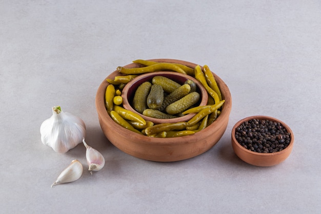 Legumes variados em pickles colocados sobre uma superfície de pedra.