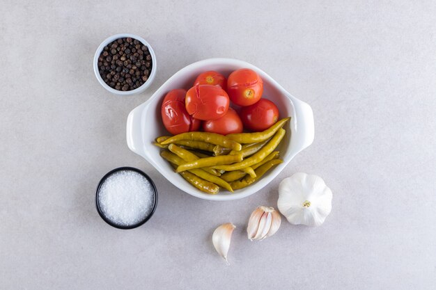 Legumes variados em pickles colocados sobre uma superfície de pedra.