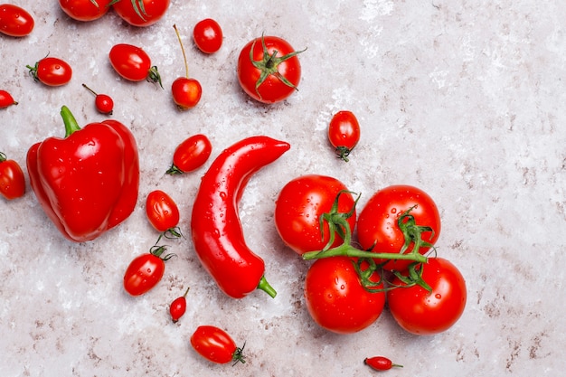 Legumes vermelhos frescos na superfície de concreto