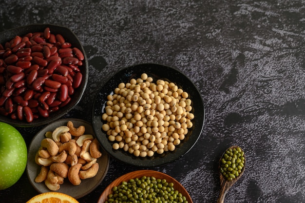 Leguminosas e frutas em uma superfície de piso de cimento preto.