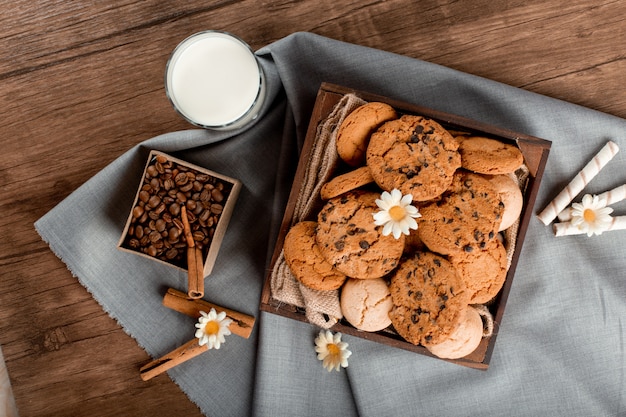 Leite, caixa de café e biscoitos em cima da mesa