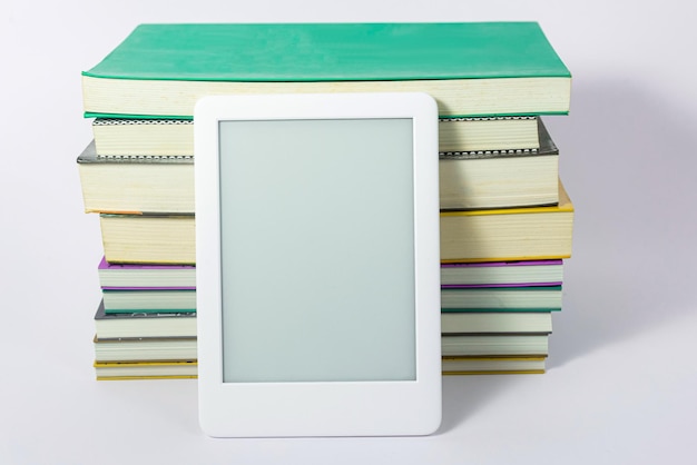 Foto grátis leitor de ebook ao lado de livros de papel