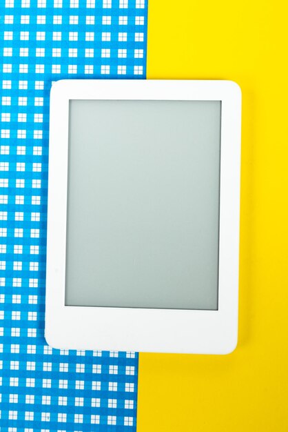 Leitor de ebook sobre fundo amarelo e azul