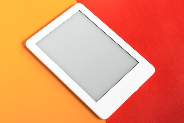 Leitor de ebook sobre fundo amarelo e vermelho