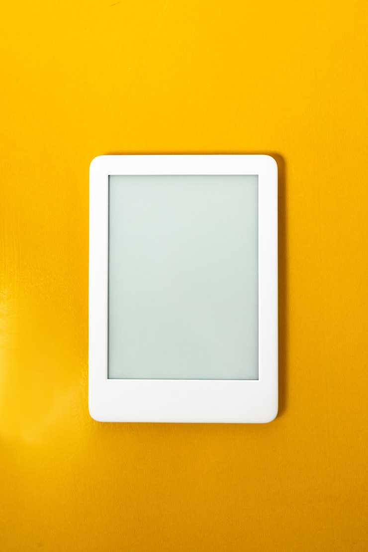Foto grátis leitor de ebook sobre fundo amarelo