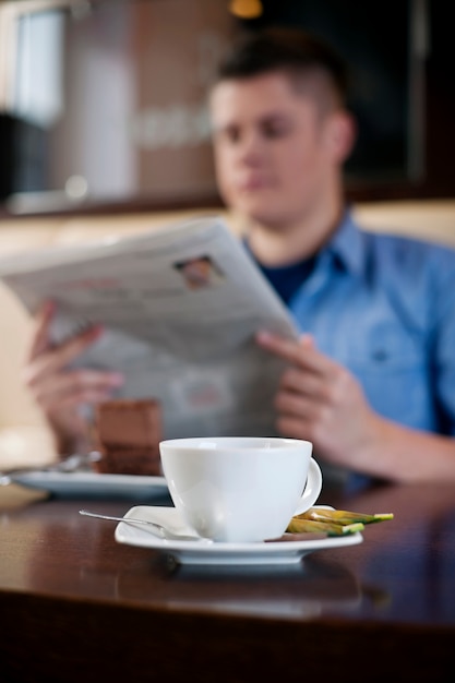 Foto grátis lendo jornal no café