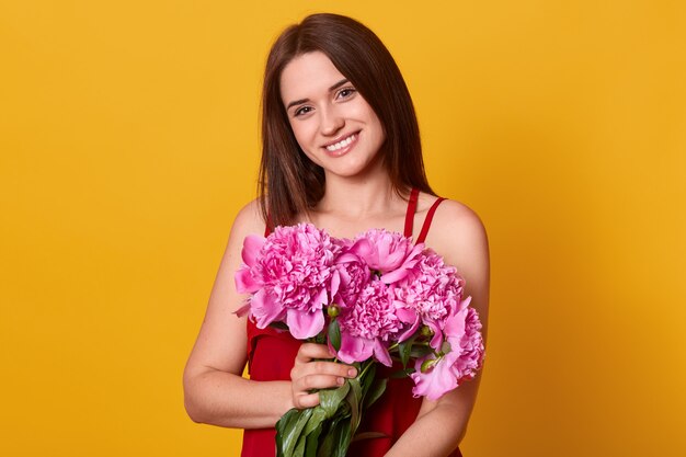 Levantamento bonito de sorriso da fêmea isolado sobre o amarelo