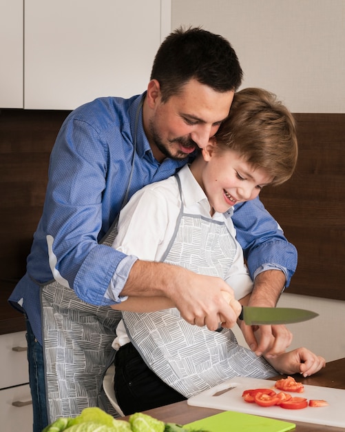 Foto grátis lição de menino na cozinha com o pai