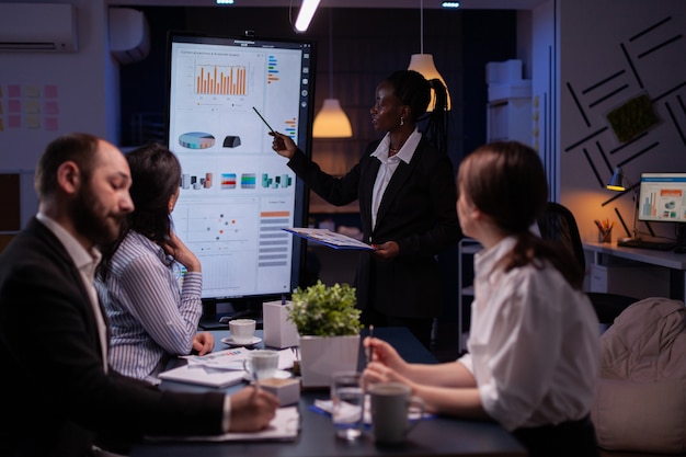 Foto grátis líder americano africano workaholic em frente ao monitor de apresentação, explicando o pr ...