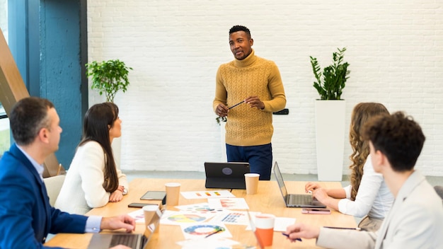 Foto grátis líder da equipe masculina negra em reunião de negócios em um escritório