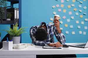 Foto grátis líder de equipe estressado e cansado com síndrome de burnout sentado no espaço de trabalho do escritório moderno. funcionário do escritório da agência cansado e exausto adormecendo na mesa por causa do trabalho de horas extras