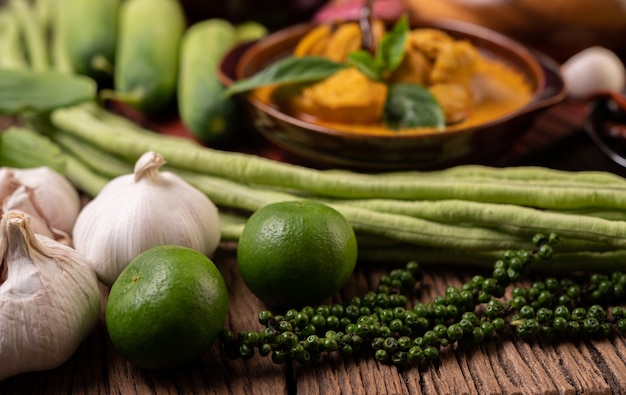 Limão, alho, feijão comprido e sementes de pimenta fresca em uma mesa de madeira