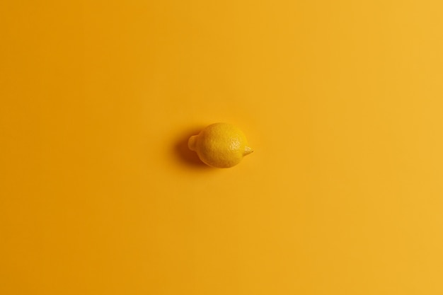 Limão amarelo suculento inteiro fresco inteiro em uma cor com o fundo. Frutas cítricas tropicais. Foto monocromática. Fonte de vitaminas. Ingrediente para fazer limonada. Comida saudável, conceito de alimentação