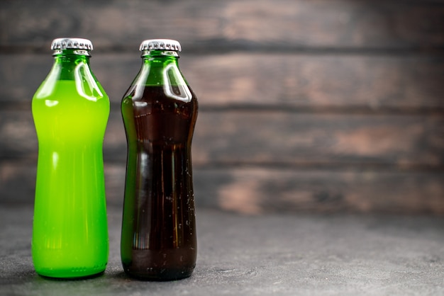 Limonada verde e preta em garrafas de vista frontal