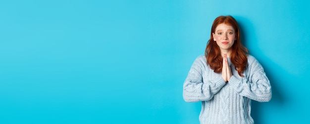 Foto grátis linda adolescente ruiva pedindo ajuda sorrindo enquanto implora por favor precisa de algo em pé o