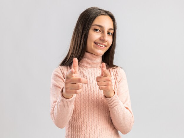 Foto grátis linda adolescente sorridente olhando para frente fazendo seu gesto isolado na parede branca com espaço de cópia