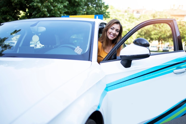 Linda aluna de condução de automóveis entrando no veículo em sua primeira aula