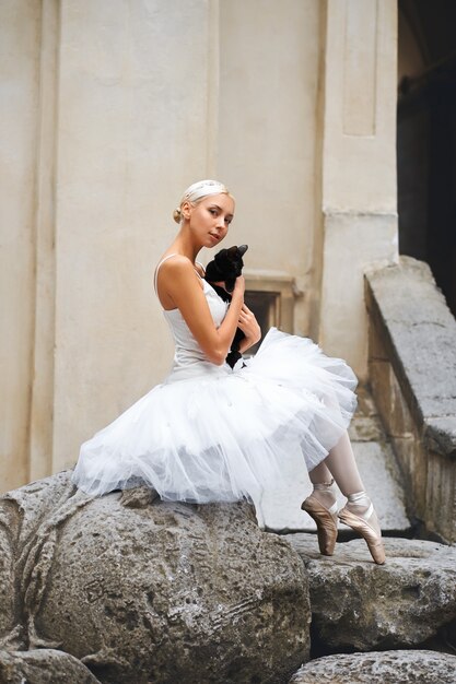 Linda bailarina acariciando gato preto