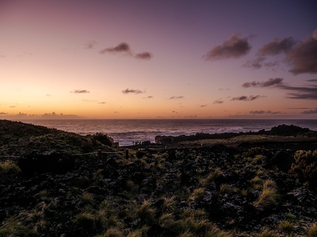 Foto grátis linda beira-mar com um pôr do sol colorido no horizonte