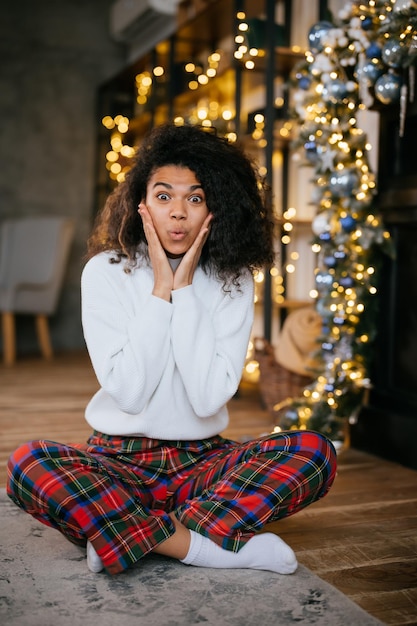 Linda e atraente mulher muito feliz senta-se no chão e olha para a câmera